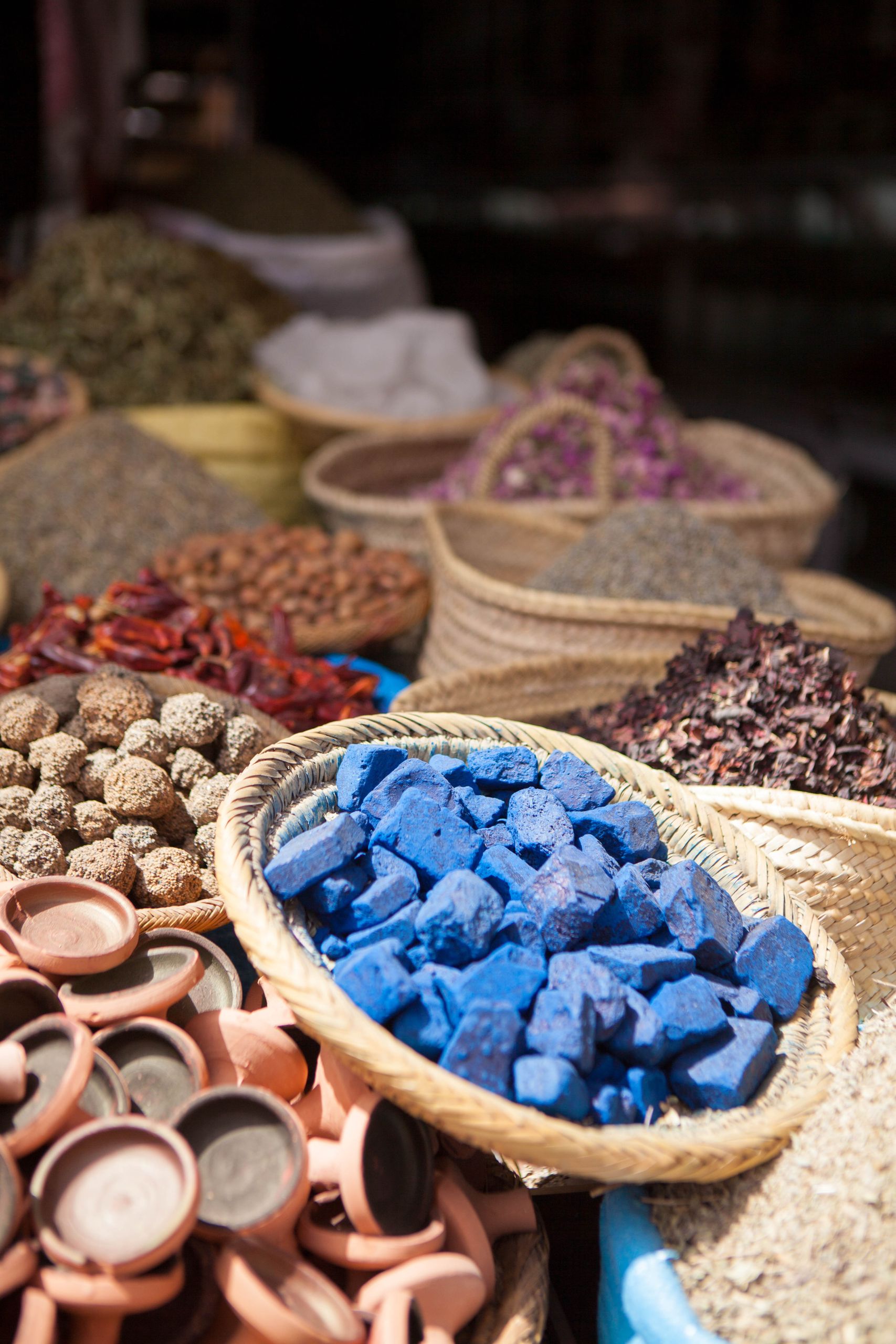 Explore the colorful spices and merchandise at a bustling Moroccan market in Marrakech.