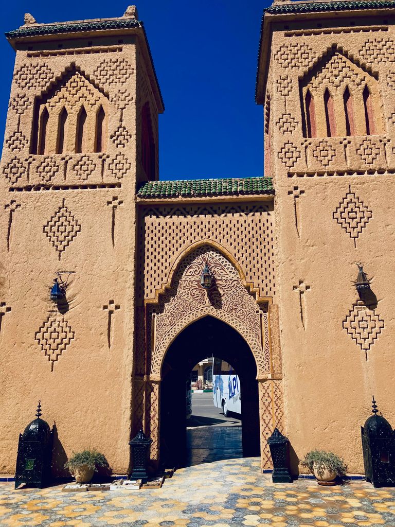 Iconic Moroccan city gate with detailed geometric patterns under a clear blue sky.